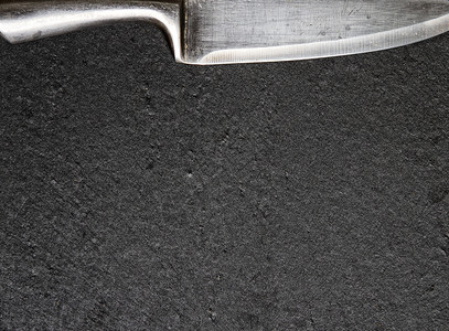 紧贴石头板平黑色块和尖利钢制厨房刀图片