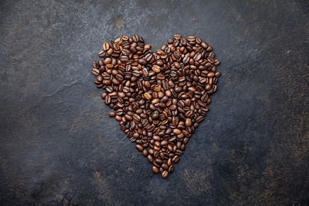 咖啡豆以深生锈背景的心形豆子平的地深生锈背景的心形咖啡豆子图片