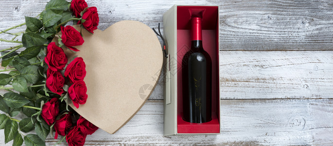 庆祝情人节快乐用红酒玫瑰和白锈木上一个心形礼物盒庆祝图片
