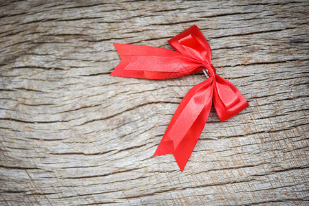 红丝结在木背景的红丝弓上赠送的完美节日手工制作的完美节日图片