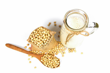 用于健康饮食和自然豆蛋白质的玻璃罐中豆奶用于健康的饮食和天然豆蛋白木勺中的豆和白底孤立的袋中干豆图片