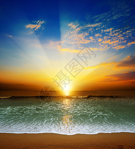海浪和沙子之上的日落令人惊叹图片