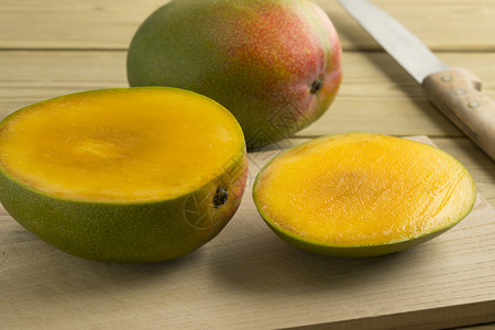 新鲜的切片芒果和背景白的整片芒果图片
