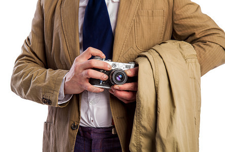穿着西装和领带的狗仔郎吉秘密拍摄一个照片在藏外套里的胶片摄影机上图片