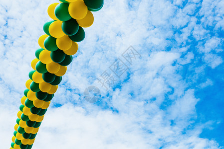 彩色气球横穿蓝天空云层背景与负复制空间的彩色气球横穿蓝天空图片