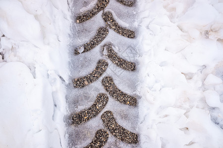 被雪覆盖的公路上的车轮轨迹图片