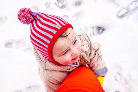小女孩在雪地拥抱父亲的大腿图片