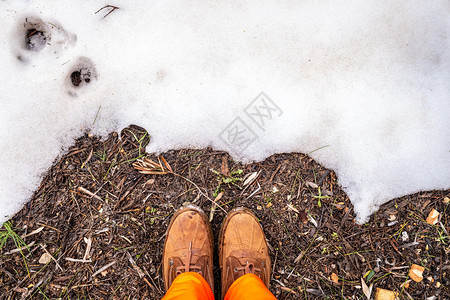 脚踩着鞋子的人站在雪田前面图片