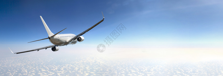 客机在云层和蓝天上空飞行图片