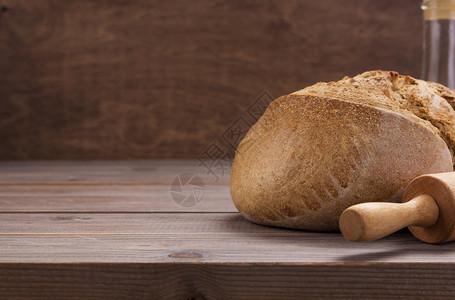 木制背景上的黑麦面包图片
