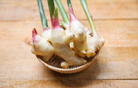 新鲜青姜用于草药天然和木材桌上的食品篮子姜根收获图片