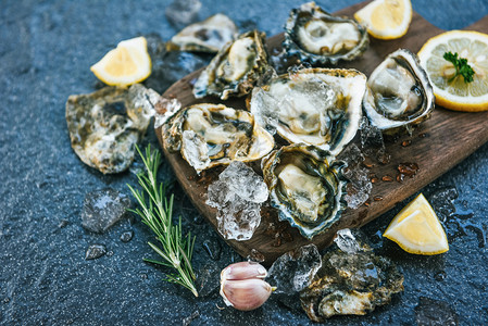 木板上新鲜的牡蛎海板底背景露天牡蛎贝壳配有草药香料柠檬迷糖餐桌和在厅美食中吃的冰上健康海鲜生牡蛎晚饭图片