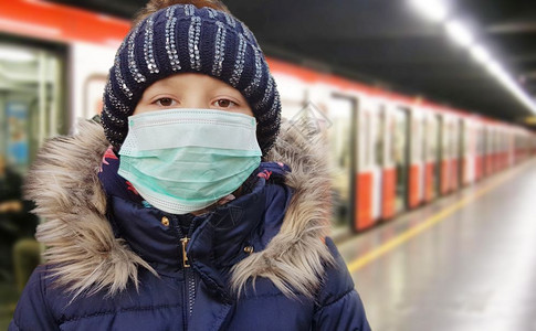 身戴保护无菌医疗面具的年轻女孩在脸上看管站的照相机流行冠状概念图片