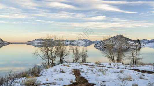 在洛基山的坡上部分冷冻的平静湖马牙储藏室BigThompson项目的一部分以及科罗拉多北部林斯堡附近的一个受欢迎娱乐地点冬季风景图片