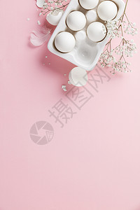 白陶瓷持头蛋和粉红背景平板复制空间的鲜花图片
