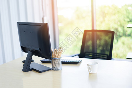 办公桌上配有计算机台式铅笔和咖啡杯的台式办公桌商务室自然背景图片