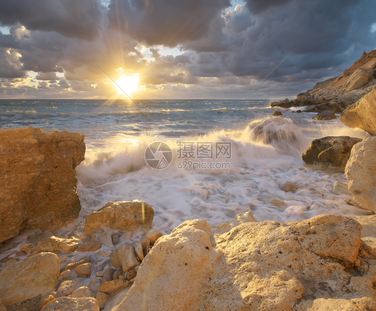 美丽的海景暴风雨中的海浪日落时会喷洒到石头上自然的构成图片