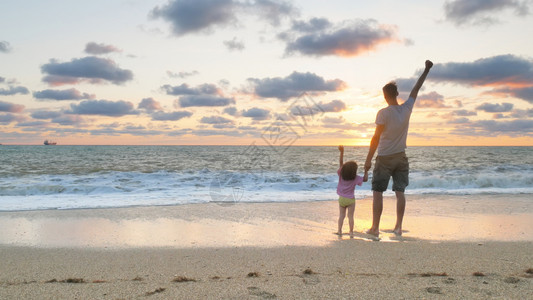 在海边站着的父亲和女儿图片
