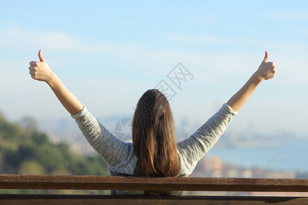 一位快乐的女士举手背面肖像图片素材