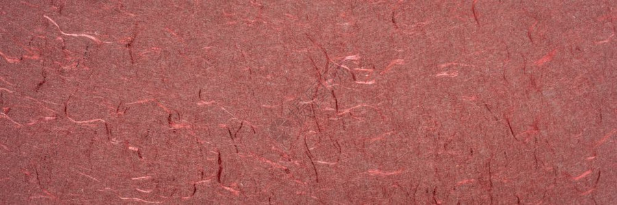 红手工印地安纸的背景和纹理由用丝纤维全景横幅回收的棉布丝纤维全景横幅制成的红手工印地安纸图片