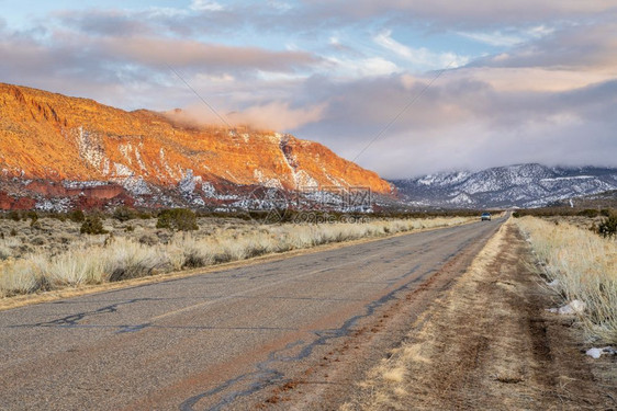 在犹他州Moab地区穿过城堡谷的一条高速公路上冬季日落背景娱乐和旅行概念有LaSal山图片