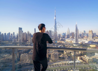 一名亚洲旅游男子在BurjKhalifa的旅馆迪拜市中心天线阿拉伯联合酋长国或阿的智能城市金融区观看旅行和度假概念图片