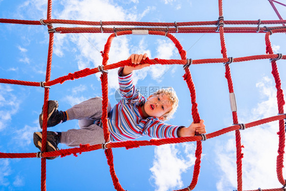 Blond男孩在儿童游乐场中攀登joaquincorbalancom图片