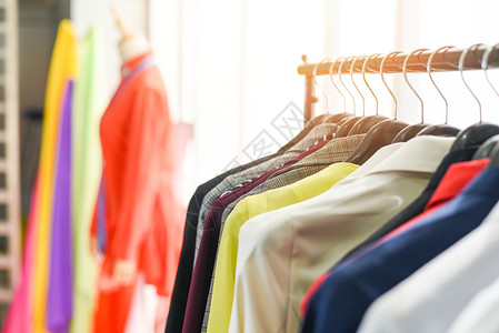 在展室衣物穿或柜架上着不同颜色服装的妇女时高清图片