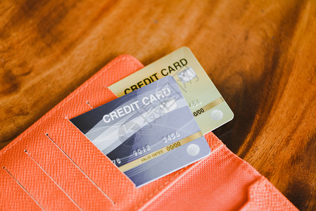 在木制表格背景木制表格背景上的钱包中信用卡图片