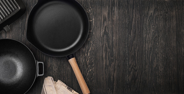 黑烹饪背景的空铁煎锅从上方查看食物背景文本空间铸铁煎锅带有复制空间的顶部视图图片