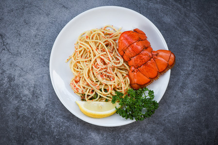 白盘子上的意大利面海鲜龙虾食品意大利面虾蛋晚饭配有香草料柠檬在餐厅桌上煮好健康的美食煮好龙虾尾图片