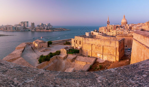 Sliema和有堡垒的旧城瓦莱塔卡梅尔山教堂圣母和保罗尔斯柯在马耳他首都市日落时圣公会支持天主教马耳他日落时瓦莱塔天空线图片