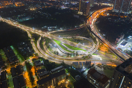 高速公路交界处的空中观察桥梁公路在交通结构概念中形成圆环顶端观察城市泰国曼谷夜间建筑景观背图片