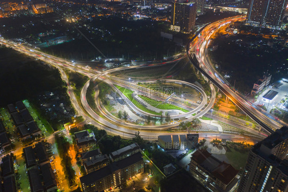 高速公路交界处的空中观察桥梁公路在交通结构概念中形成圆环顶端观察城市泰国曼谷夜间建筑景观背图片