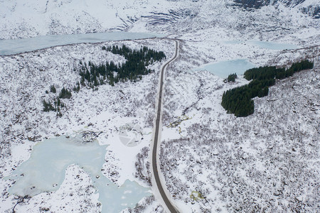 Lofoten岛挪威Nordland县欧洲Lofoten岛的桥梁和公路空中观察白雪山丘和树木冬季自然景观背图片