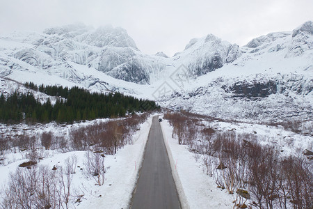 Lofoten岛挪威Nordland县欧洲Lofoten岛的桥梁和公路空中观察白雪山丘和树木冬季自然景观背图片