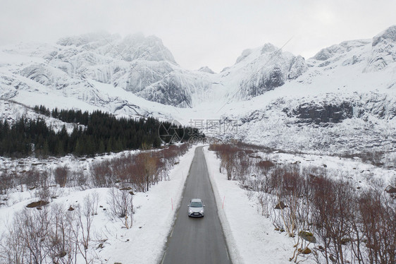 Lofoten岛挪威Nordland县欧洲Lofoten岛的桥梁和公路空中观察白雪山丘和树木冬季自然景观背图片