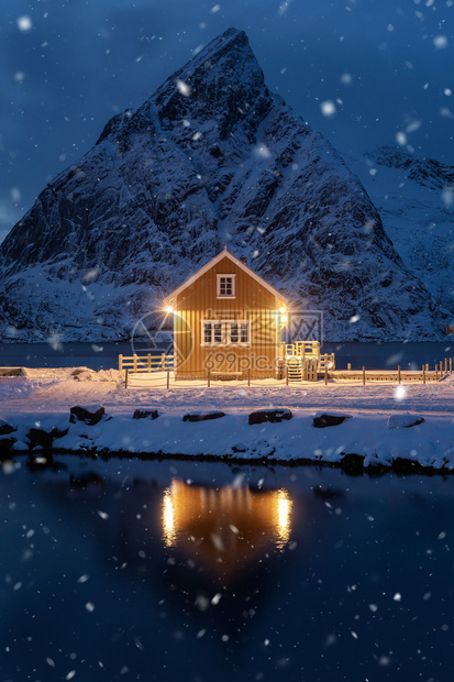 夜间的家小屋或房雷因市挪威渔业村洛福滕岛诺德兰县挪威欧洲白雪山冬季自然景观背图片