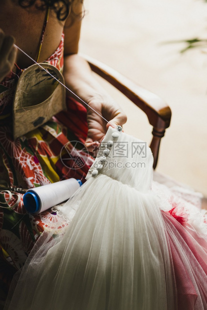 女裁缝在家里手工合婚纱线和针头图片