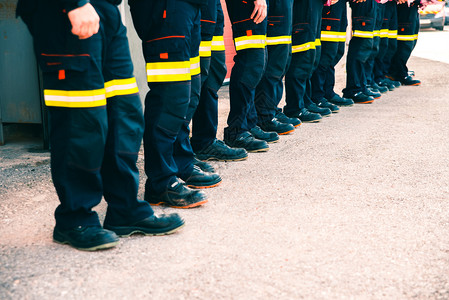 一群穿着工作制服的消防队员在团工作图片