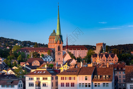 日落时瑞士最大的城市苏黎世老的屋顶和塔楼上空的中观察图片