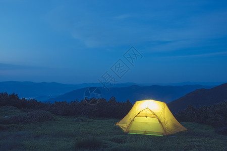 山上的黄色帐篷夜空下露营图片