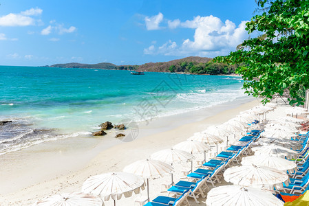 沙滩海浪和岸景看到美丽的热带风景海滩岛蓝天空和泰国度假沙椅滩夏天和树的度假地背景图片