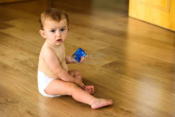 婴儿在地板上玩弄银行信用卡图片