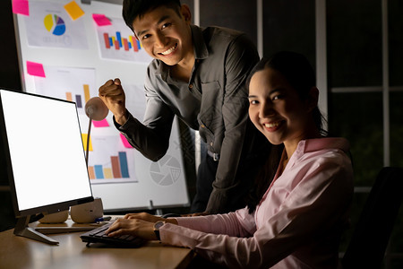 年轻的成亚洲商人和女在办公室用台式计算机深夜在白板上制作分析图为艰苦工和迟到的概念图片