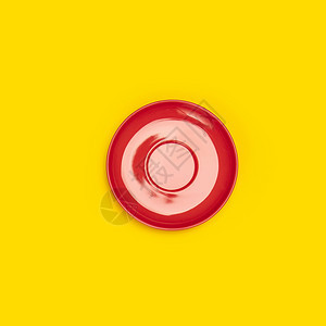 黄色背景的红陶瓷板saucer的顶部视图方形构成黄色背景的红陶瓷板碟顶部视图图片