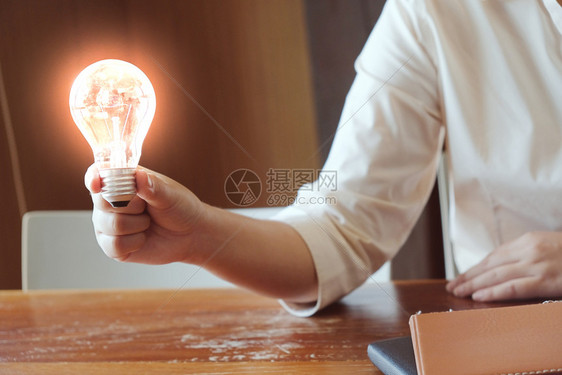 拥有灯泡概念创意和的商人想法图片