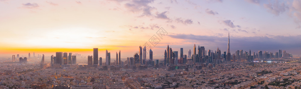 迪拜下城天线阿拉伯联合酋长国或阿金融区和智能城市商业区的空中景象日落时是天梯和高楼背景图片