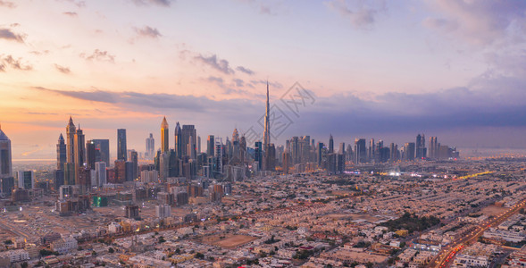 太空中的星球迪拜下城天线和高速公路阿拉伯联合酋长国或阿金融区和智能城市商业区日落时天梯和高楼大的BurjKhalifa空中观察背景