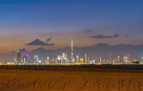 迪拜市中心有沙漠阿拉伯联合酋长国或阿金融区和商业位于智能城市日落时有天梯和高楼图片